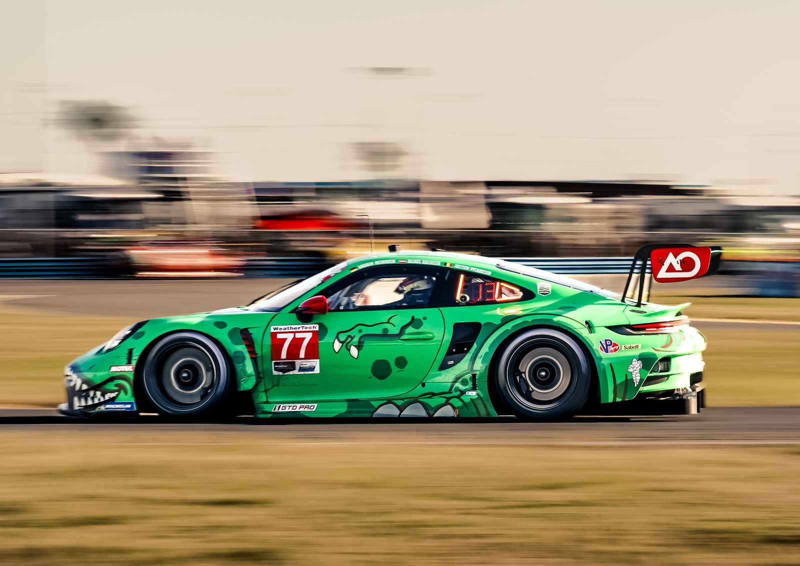 Green livery Porsche GT3 race car on track