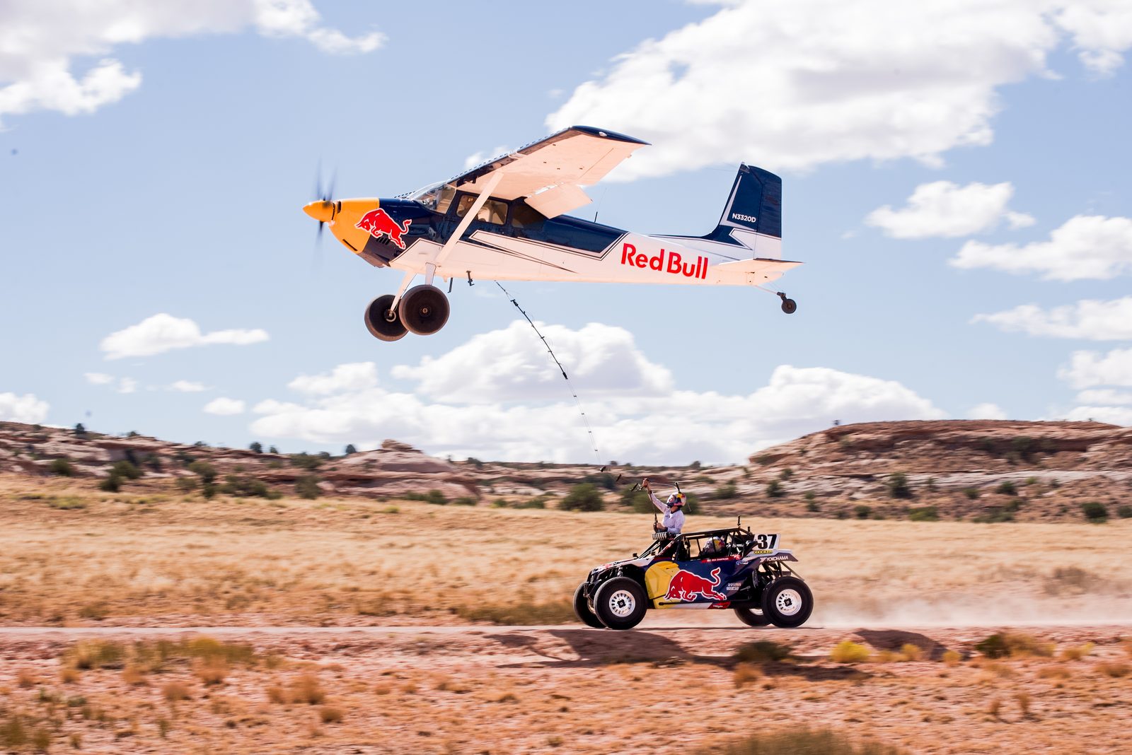 Red Bull stunt plane and off-road buggy in the desert