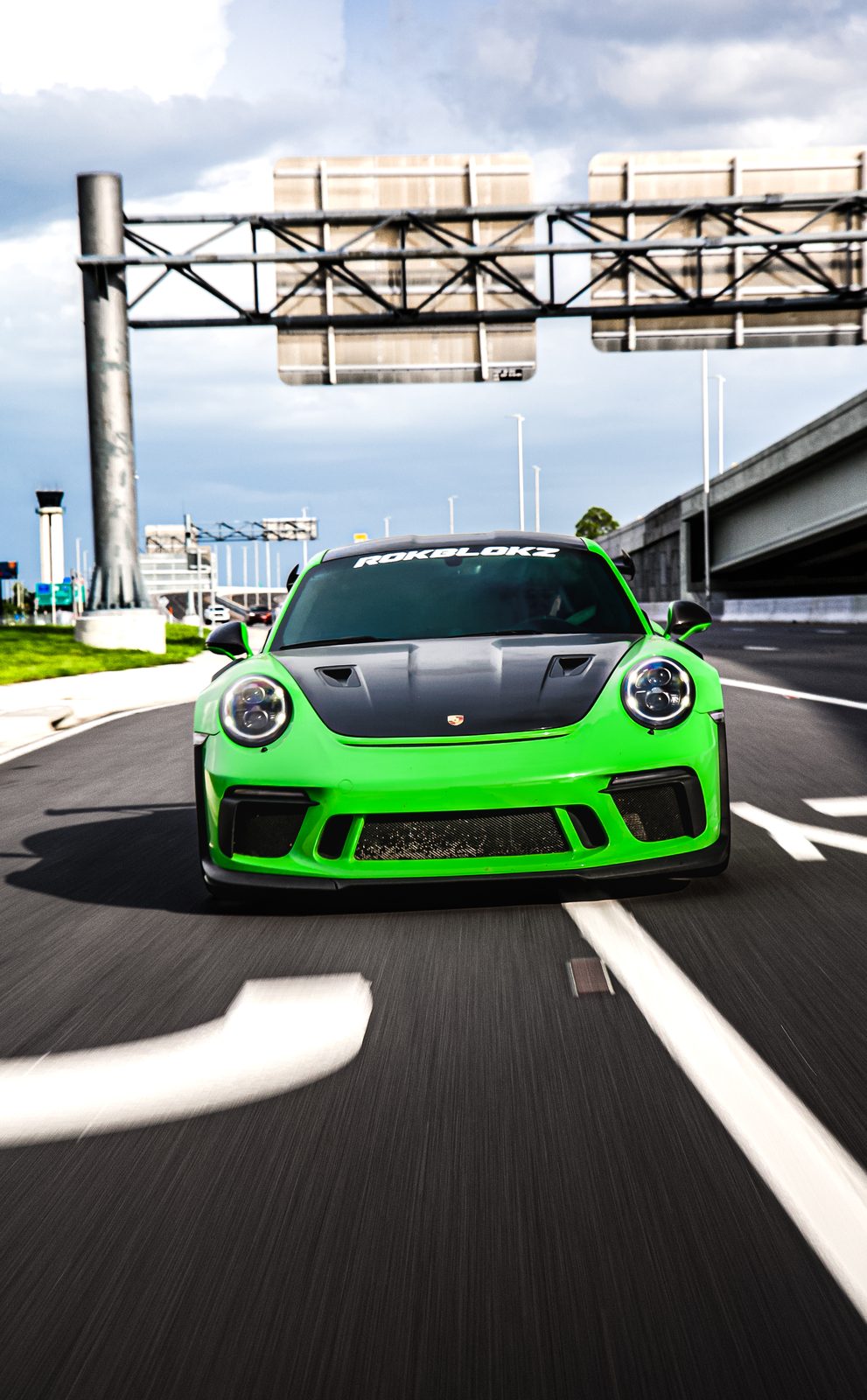 Green Porsche GT3 driving on the highway