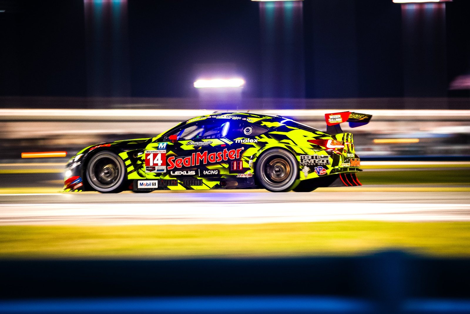 Lexus GT race car at speed under the lights during a night race