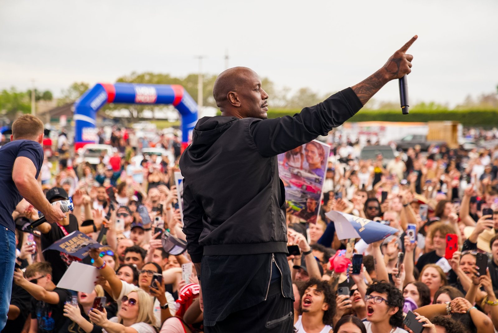 Performer on stage pointing out over a huge festival crowd