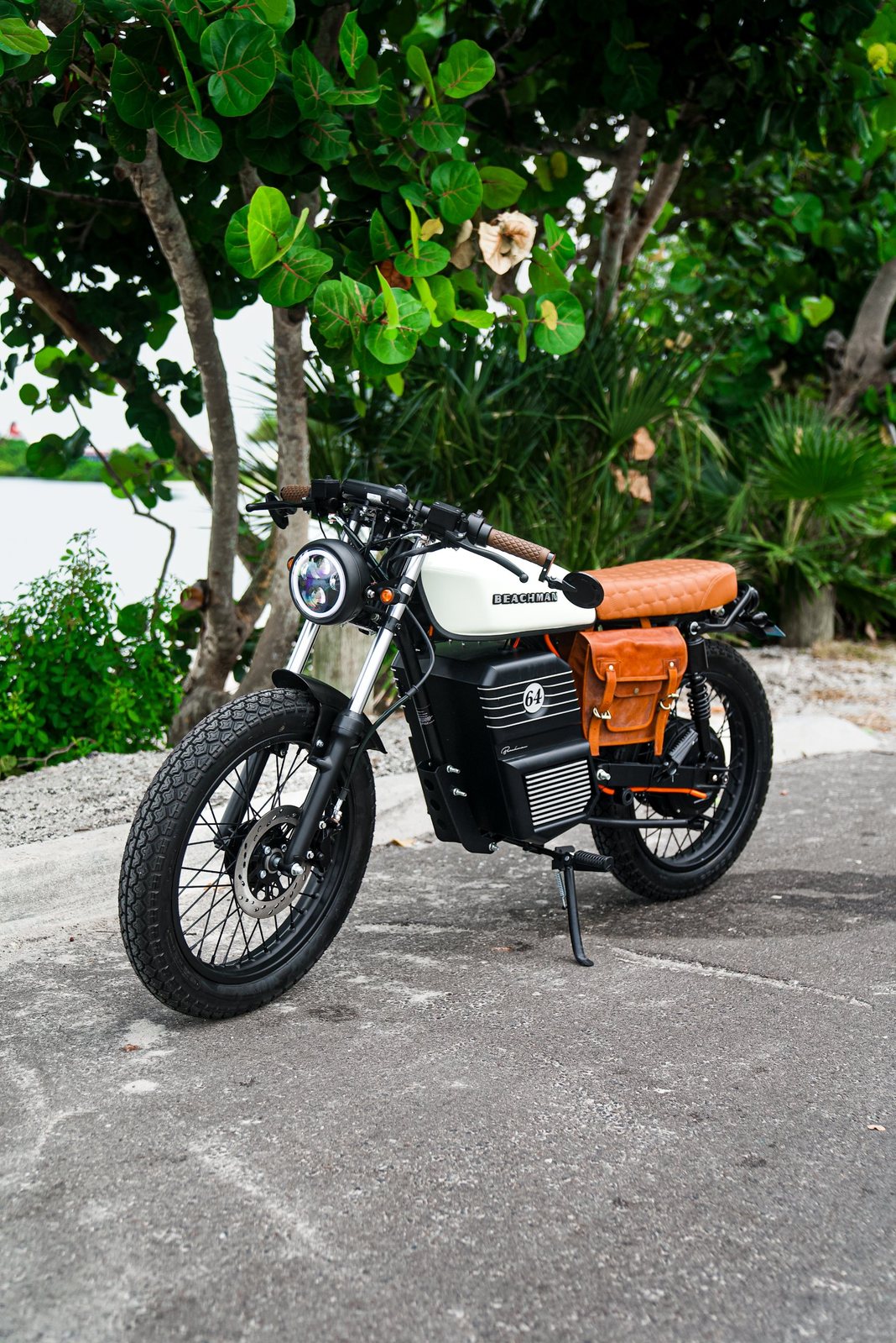 Beachman electric cafe racer motorcycle parked under sea grape trees