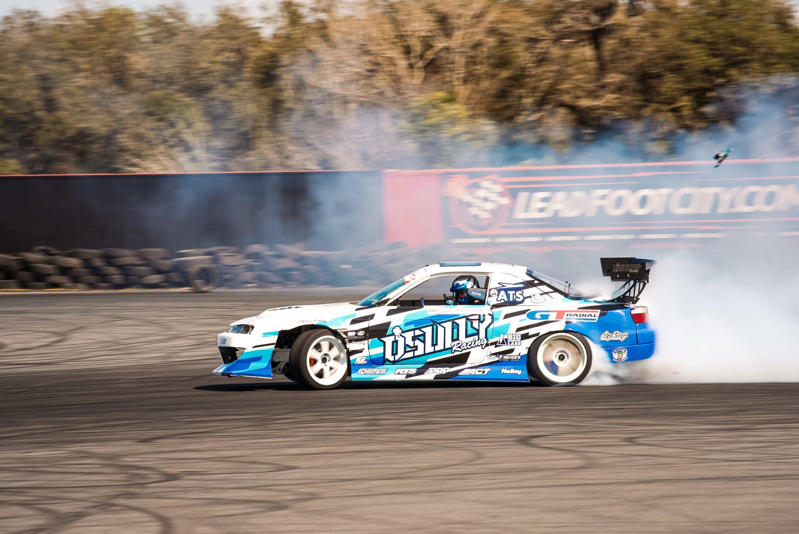White and blue drift car pouring tire smoke at Lead Foot City