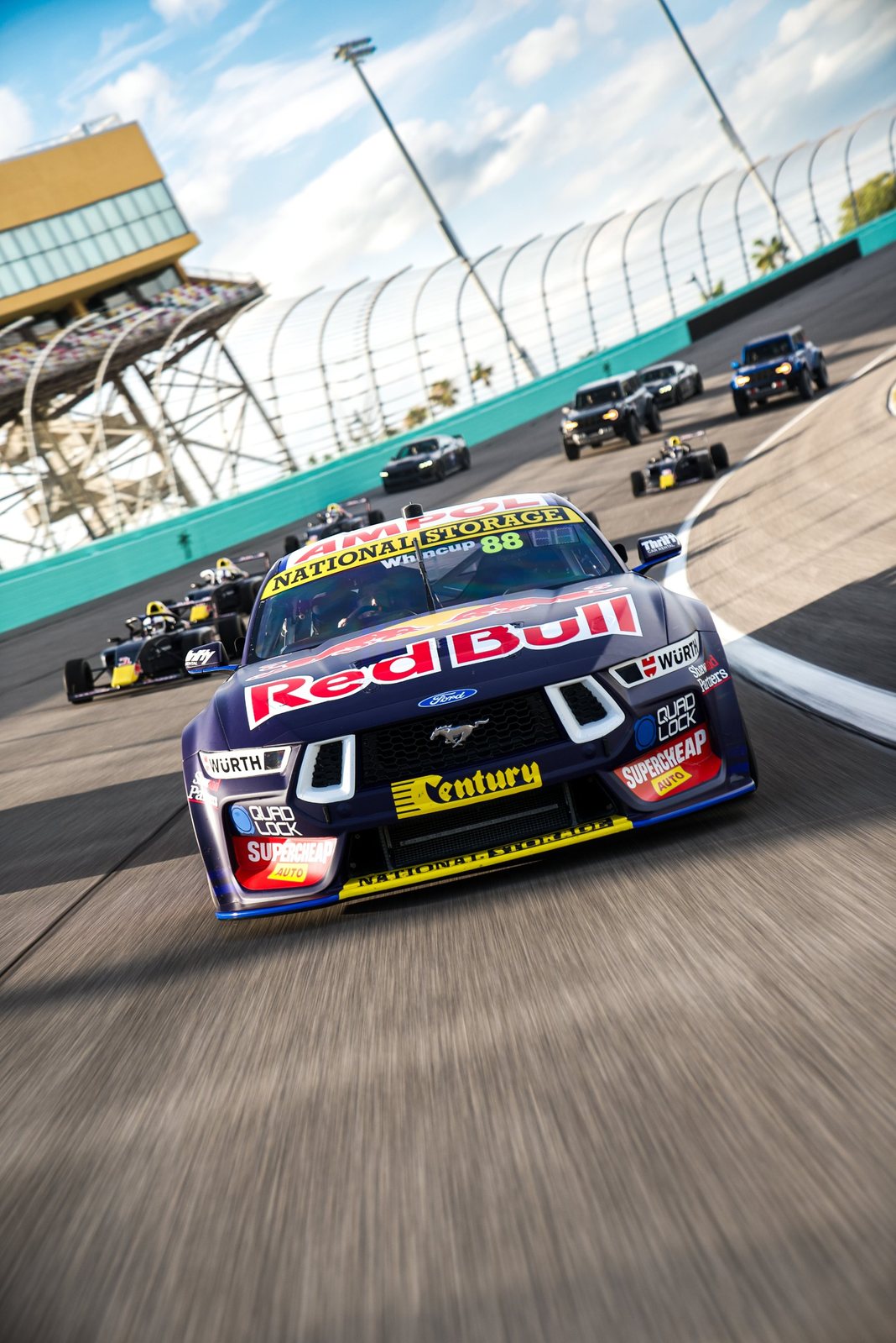 Red Bull Mustang Supercar leading formula cars around the oval