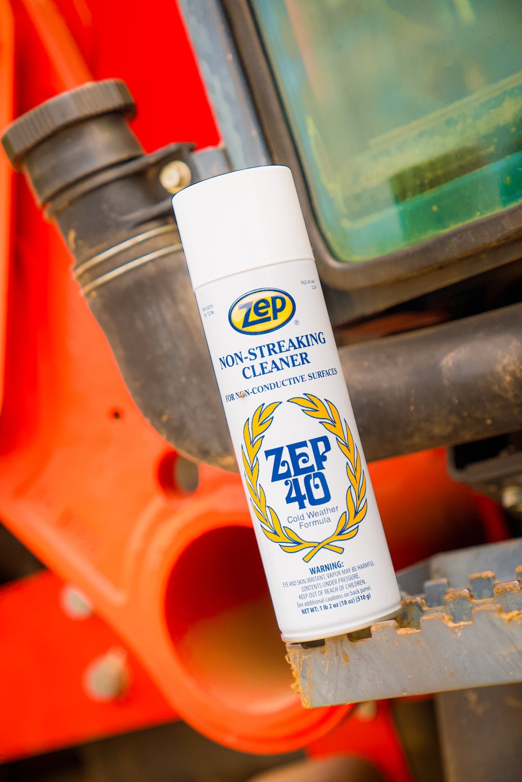 Zep 40 cleaner can on the step of an orange tractor