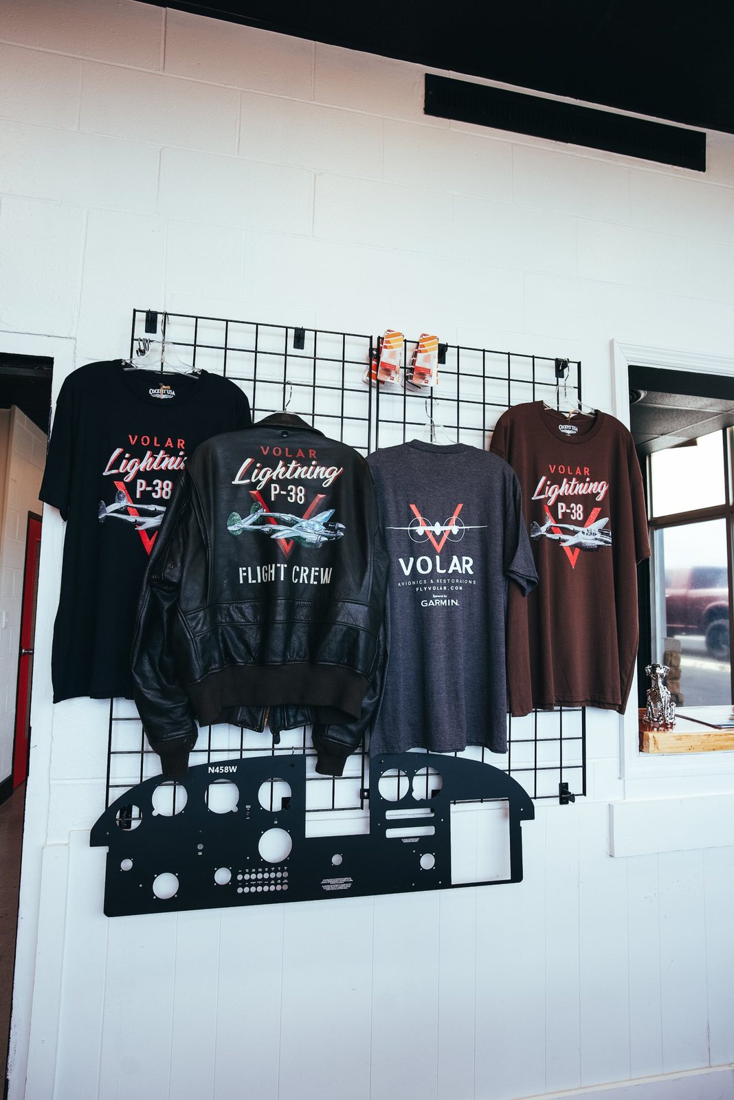 Volar Avionics merch wall with P-38 Lightning flight crew jacket
