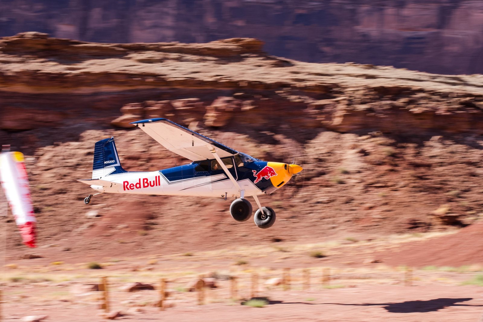 Red Bull bush plane landing on a desert canyon airstrip