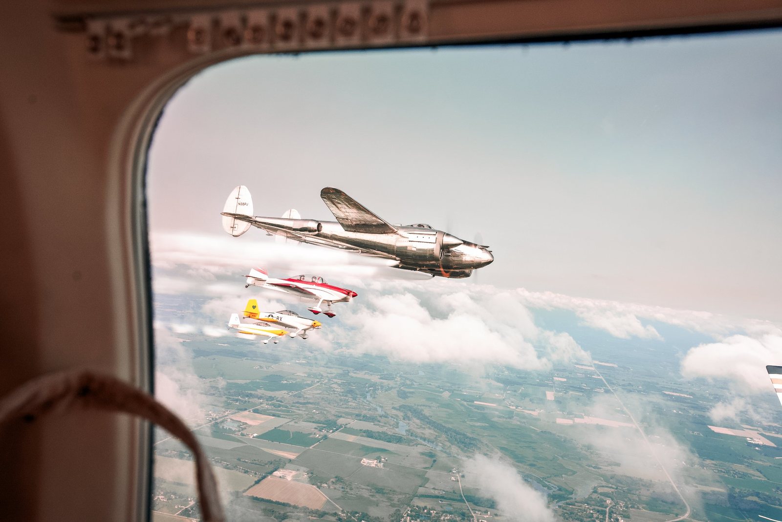 P-38 Lightning leading a formation, shot through an airplane window